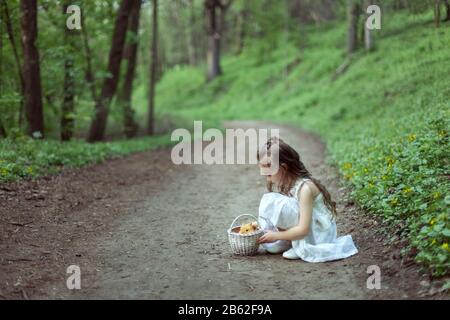 Ritratto di una bambina carina con un coniglio nella foresta primaverile. Foto Stock