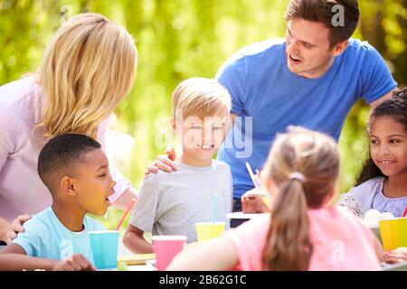 Genitori E Figlio Che Celebrano Il Compleanno Con Gli Amici Che Hanno Partito In Giardino A Casa Foto Stock