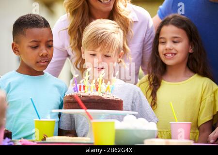 Genitori E Figlio Che Celebrano Il Compleanno Con Gli Amici Che Hanno Partito In Giardino A Casa Foto Stock