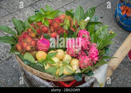Cestino di frutta esotica colorato, contenente frutti di drago, Rambutan e pere, in vendita nel mercato di Dali, Yunnan, Cina Foto Stock