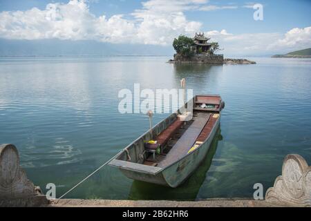 Attracco barca nel lago, sullo sfondo una casa su una piccola isola. Area di Dali, Yunnan, Cina Foto Stock