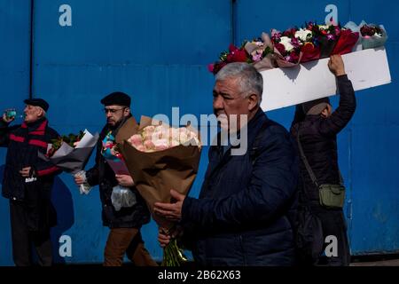 Mosca, Russia. 7th marzo 2020. Un uomo porta boquets di fiori fuori dal mercato dei fiori Rizhsky prima della Giornata Internazionale della Donna a Mosca, Russia Foto Stock