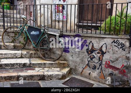 Bicicletta tradizionale utilizzata come pubblicità per il Cafe Antiquari e opere d'arte canine di Sonríe, @inkterrorist nel centro storico di Palma, Spagna, Europa. Foto Stock