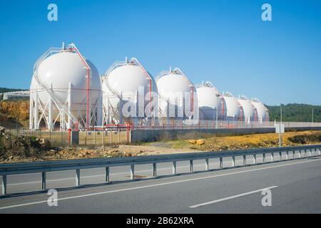 Serbatoi di stoccaggio GNL su strada. Vista soleggiata e chiara. Serbatoi di stoccaggio del gas di petrolio liquefatto (GPL). Impianto a gas. Foto Stock