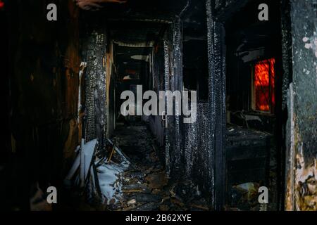 Corridoio di casa di legno bruciato scuro dopo il fuoco. Foto Stock