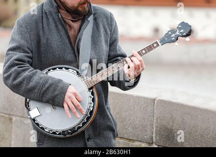 Un musicista di strada che gioca un banjo all'aperto Foto Stock