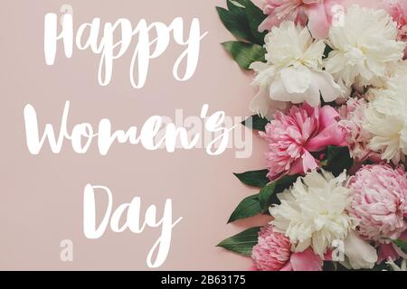 Testo Happy Women's Day. Happy Women's day lettering su elegante colore rosa peonies piatto. Biglietto di auguri floreale. Bella fiori di peonia, immagine tenera. 8 Foto Stock