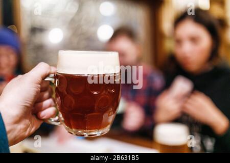 Amici bere birra artigianale autentica in pub ceco e clinking Foto Stock
