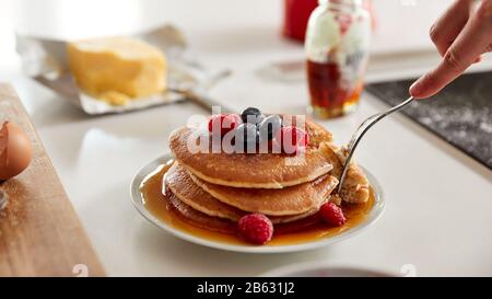 Donna Che Mangia Frittelle Appena Fatte O Crepes Con Sciroppo E Patatine Fritte A Tavola Per Il Giorno Del Pancake Foto Stock