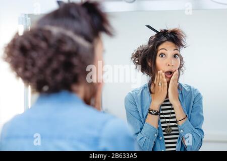 Le emozioni della donna hanno sorpreso il suo stile di capelli nel barbiere. Foto Stock