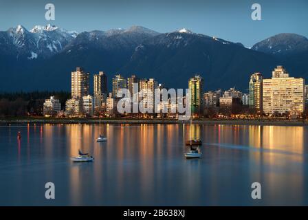 Vancouver Mountains E West End Dusk. Barche a vela ancorate in English Bay. Sullo sfondo ci sono le montagne della North Shore innevate. Vancouver, Briti Foto Stock