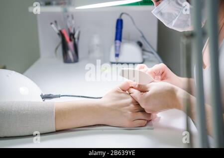 La donna in una manicure. Professional procedura manicure Foto Stock