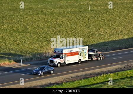 Spostamento del camion in direzione U-Haul verso nord nell'Interstate i-5 con oggetti personali e un prelievo da trainare mentre qualcuno si sposta fuori DA LA andando verso nord in California Foto Stock