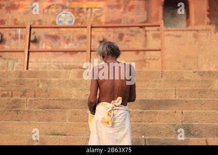 Vecchio uomo si trova di fronte al forte di Chet Singh dopo aver preso un bagno santo Foto Stock