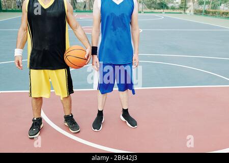 Sudati giovani sportivi stanchi dopo aver giocato a basket su campo esterno Foto Stock