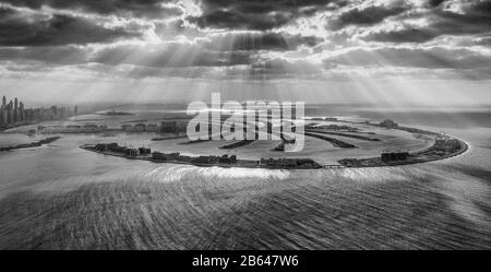 Dubai, Emirati Arabi Uniti. Le forme geometriche di Palm Jumeirah dall'elicottero al tramonto con le nuvole. Foto Stock