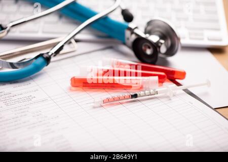 Rapporto di analisi del sangue con le provette per il prelievo di campioni di sangue a colori lavanda Foto Stock