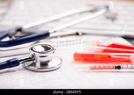 Rapporto di analisi del sangue con le provette per il prelievo di campioni di sangue a colori lavanda Foto Stock