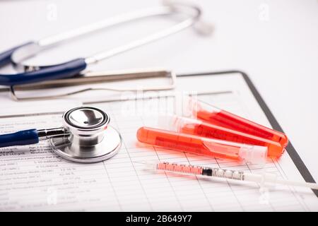 Rapporto di analisi del sangue con le provette per il prelievo di campioni di sangue a colori lavanda Foto Stock