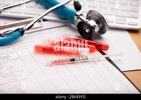 Rapporto di analisi del sangue con le provette per il prelievo di campioni di sangue a colori lavanda Foto Stock