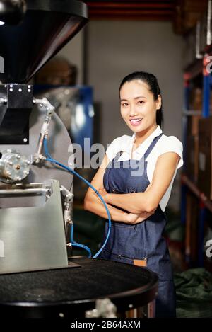 Ritratto di giovane lavoratore vietnamita abbastanza sicuro che lavora roaster professionale Foto Stock