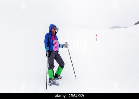 Gruppo escursionistico con bastoni da trekking con hard climbing in inverno neve tempesta Foto Stock