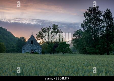 Piccola cappella francese all'alba con un campo d'orzo Foto Stock