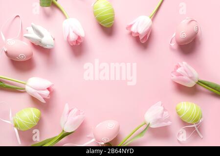 Cornice di Pasqua di fiori rosa freschi, coniglietto, uova colorate e coniglietto rosa. Vista dall'alto con spazio di copia. Buona vacanza di Pasqua. Biglietto d'auguri. Foto Stock