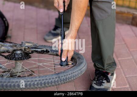 L'uomo pompò la ruota della bicicletta Foto Stock