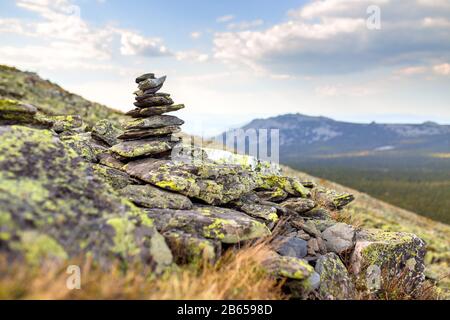 Granito cairn pietra come un segno di navigazione sulla cima della montagna Foto Stock