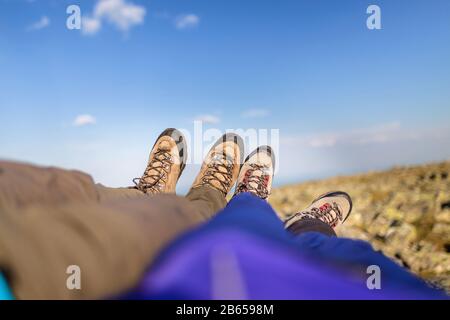 Due escursionisti mettere i piedi e prendere un riposo Foto Stock