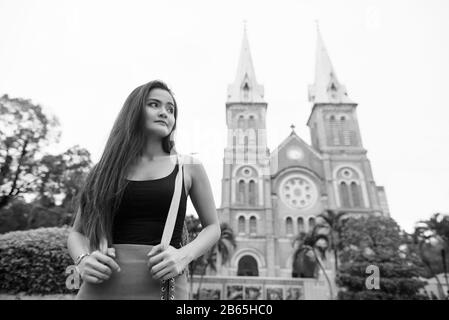 Giovane bella donna turistica asiatica contro la vista della cattedrale Foto Stock