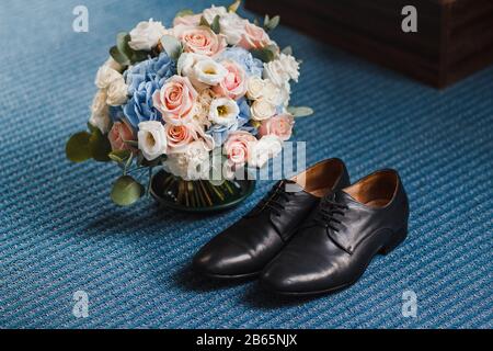 Mattina dello sposo. Scarpe e bouquet di nozze su un pavimento Foto Stock