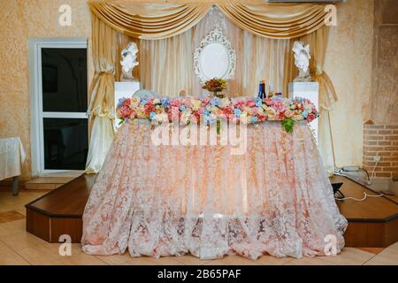 Decorazione di un tavolo del presidium per matrimoni al banchetto in color pastello. Un decor e una floristica da matrimonio per un matrimonio cremisi Foto Stock