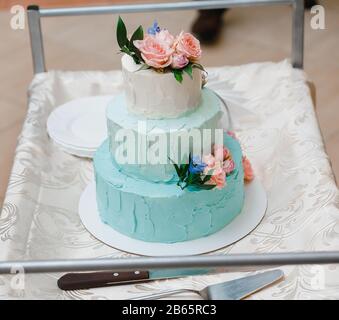 Torta nuziale in bianco e blu nel banchetto di matrimonio, adornata con fiori Foto Stock