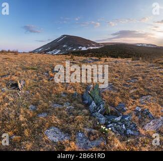 Vista panoramica del tramonto sulla colorata cima di una collina rocciosa bald dal crinale di montagna Foto Stock