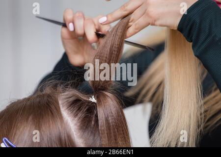 mani di donna pettinare i capelli il suo cliente nel salone di bellezza Foto Stock