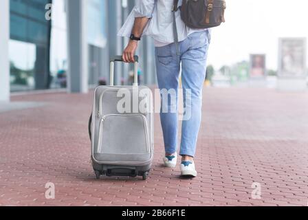 Strada Per L'Aeroporto. Uomo Irriconoscibile A Piedi Con Suitcase E Zaino All'Aperto Foto Stock