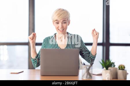 Allegra Business Lady Che Scuote I Fists Celebrando Il Successo In Ufficio Moderno Foto Stock