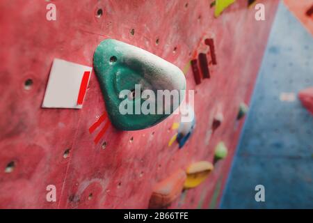 parete da arrampicata in palestra moderna con vari ganci colorati Foto Stock