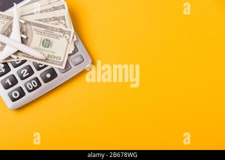 Aprile dell'anno è giorno di imposta, calcolatore di primo piano di primo piano di vista e soldi del dollaro, sul concetto giallo di preventivo di finanza di affari di fondo con la copia sp Foto Stock