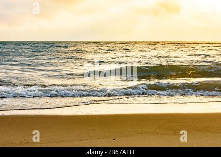 Tramonto sul mare dell'isola di Ilhabela a San Paolo litoral con la spiaggia, le onde, l'oceano e l'orizzonte durante l'estate Foto Stock