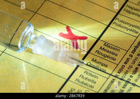 Vaccinazione contro il morbillo, scheda di vaccinazione, siringa con vaccino contro il morbillo, immagine simbolica, Foto Stock