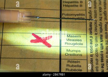 Vaccinazione contro il morbillo, scheda di vaccinazione, siringa con vaccino contro il morbillo, immagine simbolica, Foto Stock