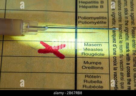Vaccinazione contro il morbillo, scheda di vaccinazione, siringa con vaccino contro il morbillo, immagine simbolica, Foto Stock