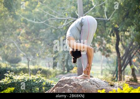 Adatta donna fare esercizio di stretching al parco all'aperto Foto Stock