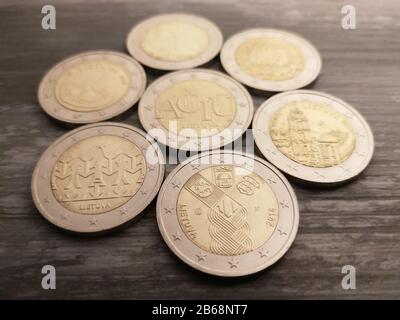 Raccolta di tutte le monete commemorative da 2 euro su sfondo ligneo Foto Stock