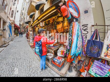 29 SETTEMBRE 2017, ISTANBUL, TURCHIA: Donna che trascorre il tempo sulla tradizionale strada del mercato del bazar turco e acquista vestiti e borse Foto Stock