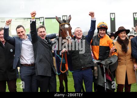 Metti il bollitore su cavalcato da Aidan Coleman celebra la vittoria del Racing Post Arkle Challenge Trophy Novices' Chase con il Trainer Henry De Bromhead (seconda a sinistra) il giorno uno del Cheltenham Festival a Cheltenham Racecourse, Cheltenham. Foto Stock