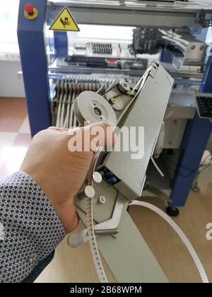 Pick and place machine feeder loaded with reel of electronics surface mount Technology SMT components Foto Stock